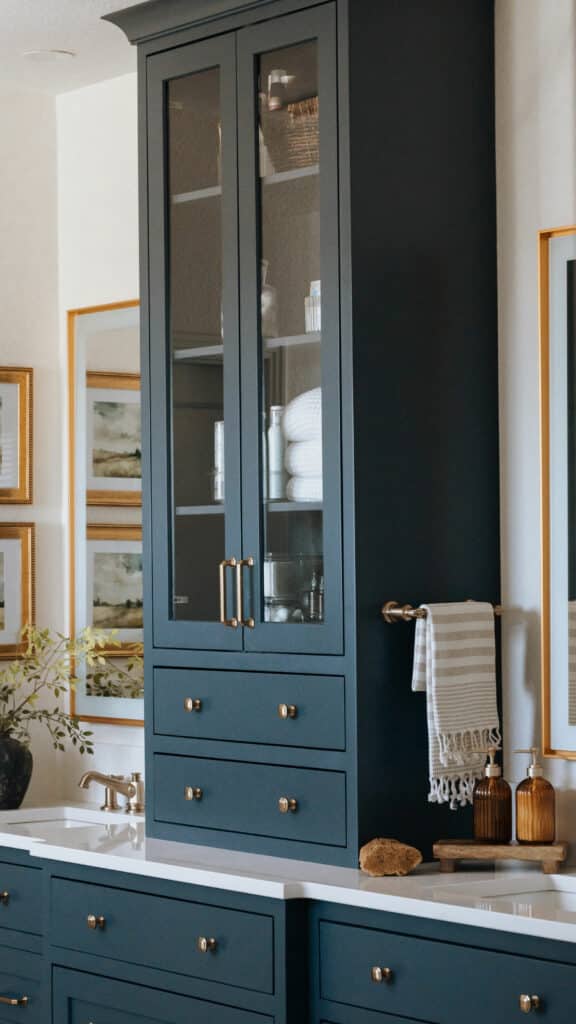 Custom inset maple bathroom vanity in Niwot CO by Harris Timberworks featuring brass hardware, glass upper cabinets, and furniture-style base design.